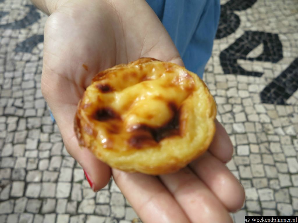 Dit is de Pastel de Belém waar je zo lang voor in de rij stond. Alleen bij  banketbakker Antiga Confeiteria de Belém mag de naam Pastel de Belém gebruiken. De imitaties die je elders in Portugal koopt heten Pastel de Nata.